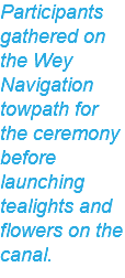 Participants gathered on the Wey Navigation towpath for the ceremony before launching tealights and flowers on the canal.